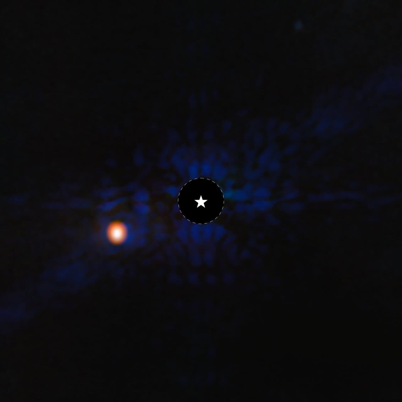A dark circle outlined with a dashed white line and marked with a star symbol, surrounded by faint blue texture, with a bright orange dot off to the left